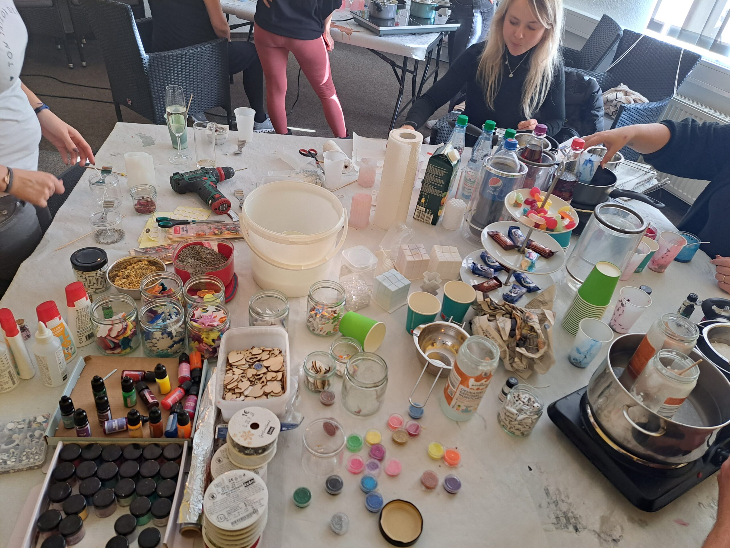 DIY-Kerzen-Workshop in Fulda: Teilnehmer gestalten individuelle Kerzen mit Materialien wie Farbpigmenten, ätherischen Ölen und getrockneten Blumen, ideal für kreative Teambuilding-Aktivitäten.